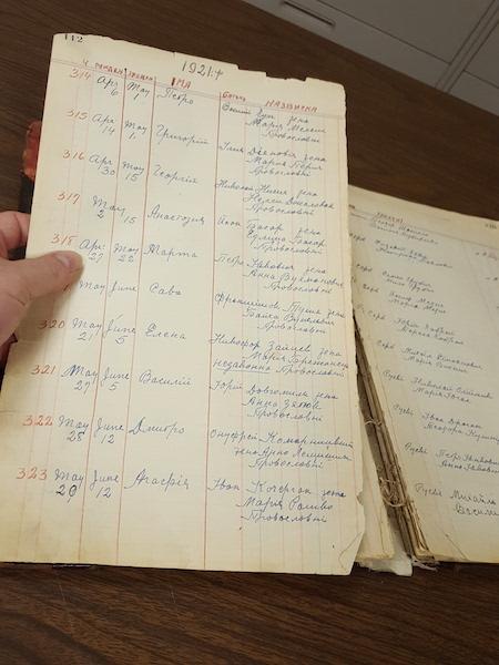 Archivist holding a page from a parish register book that has become detached
